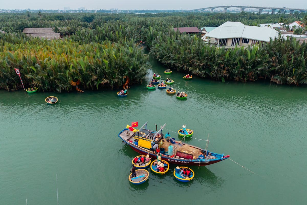 Round bamboo basket boat being paddled through coconut palm waterways in Cam Thanh village near Hoi An