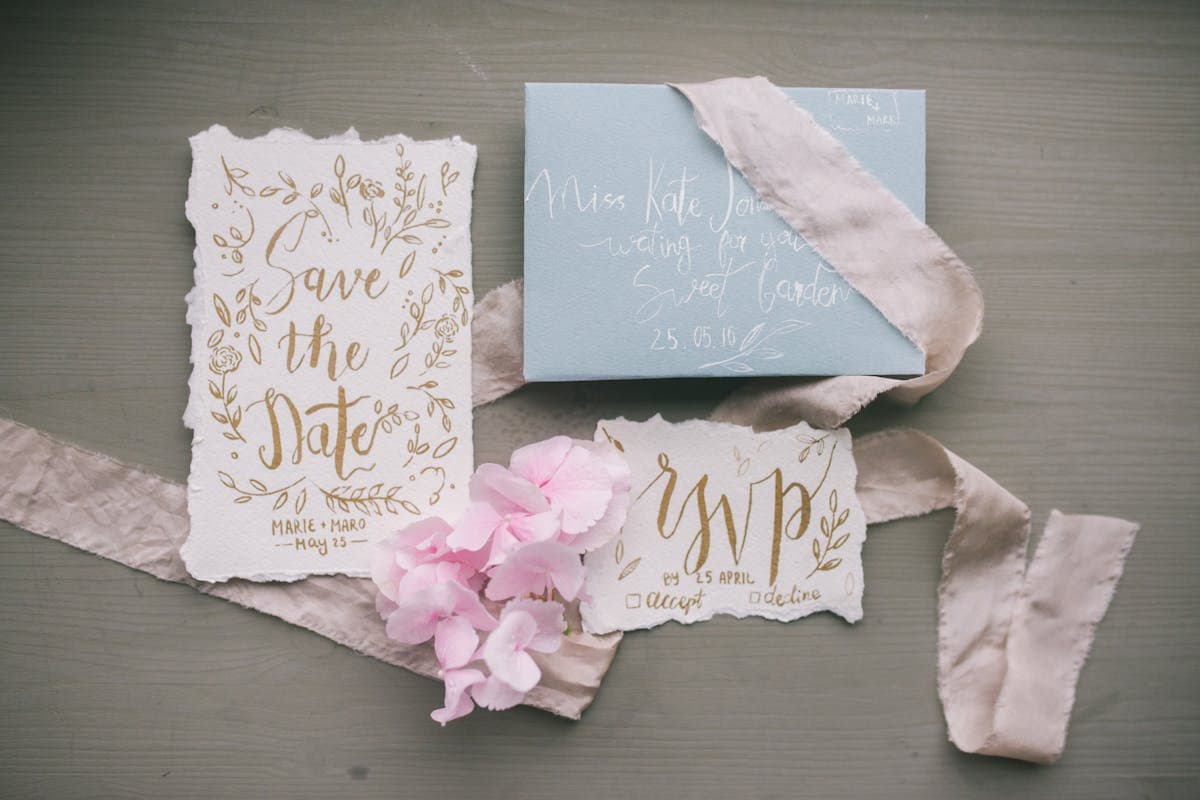 Elegant wedding invitation suite with envelope and calligraphy laid on a neutral table