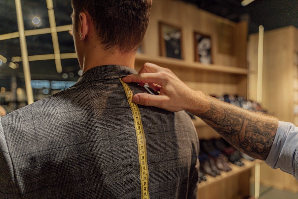 Traditional Savile Row tailor shopfront in London with gold lettering and suits in the window