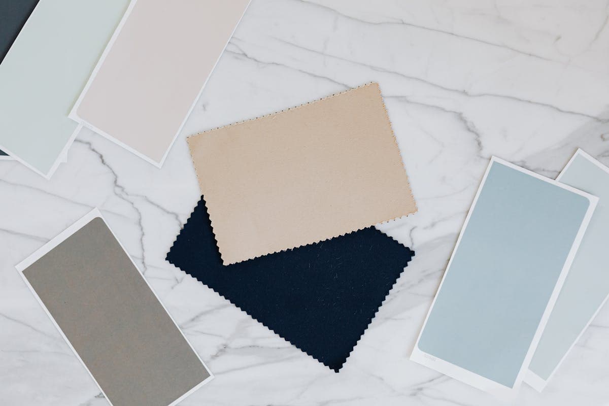 Linen suit fabric swatches in sage green, tan, navy, cream and chocolate brown laid out as a summer 2026 color palette
