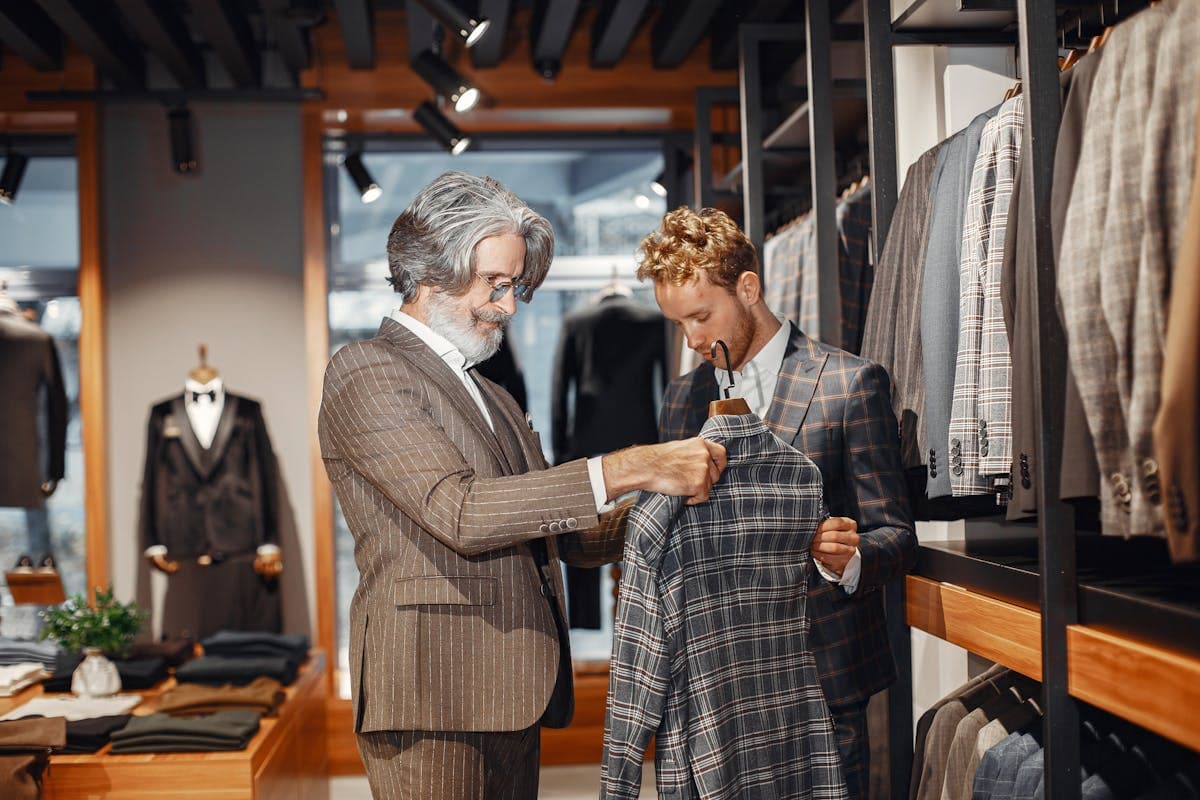 Row of off-the-rack suits in neutral colors hanging in a department store