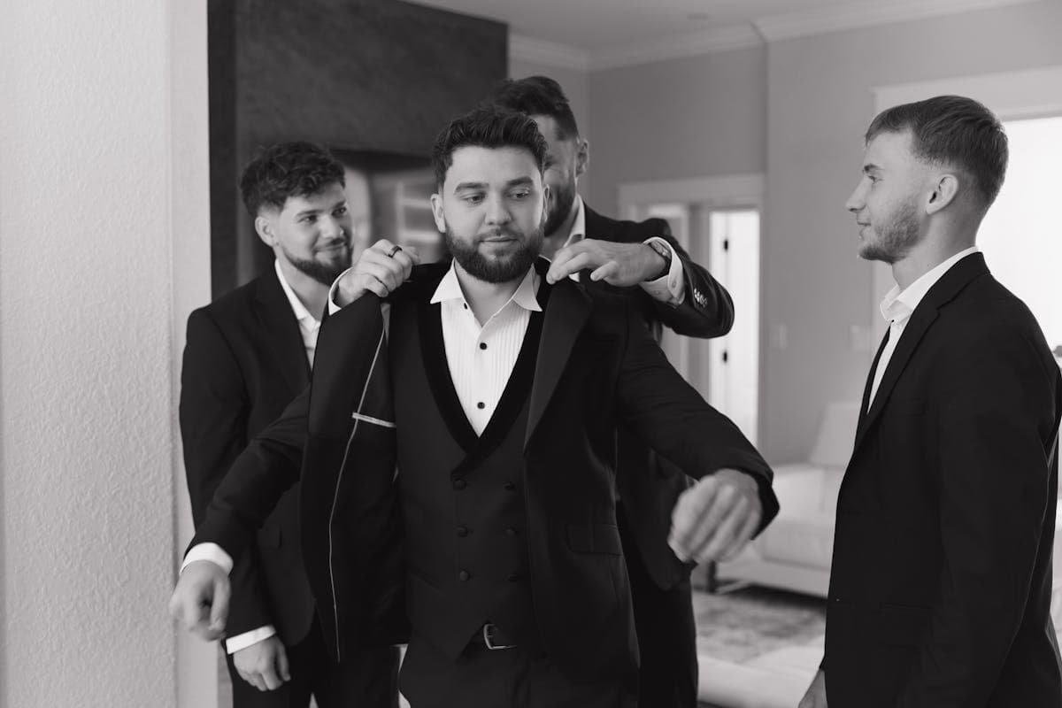 Groom and groomsmen standing together in matching suits before a wedding