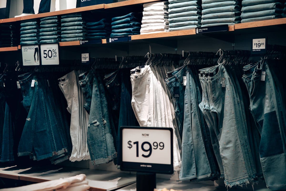 Close-up of a price tag hanging from the sleeve of a suit on a retail rack