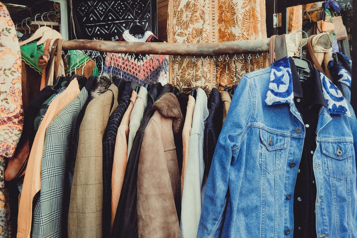 Secondhand suit jackets crowded on a thrift store rack