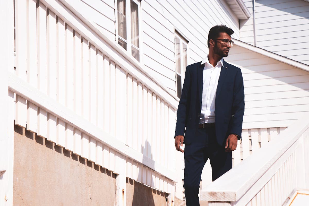 Man in a slim minimal dark navy suit with clean lines and no pocket square