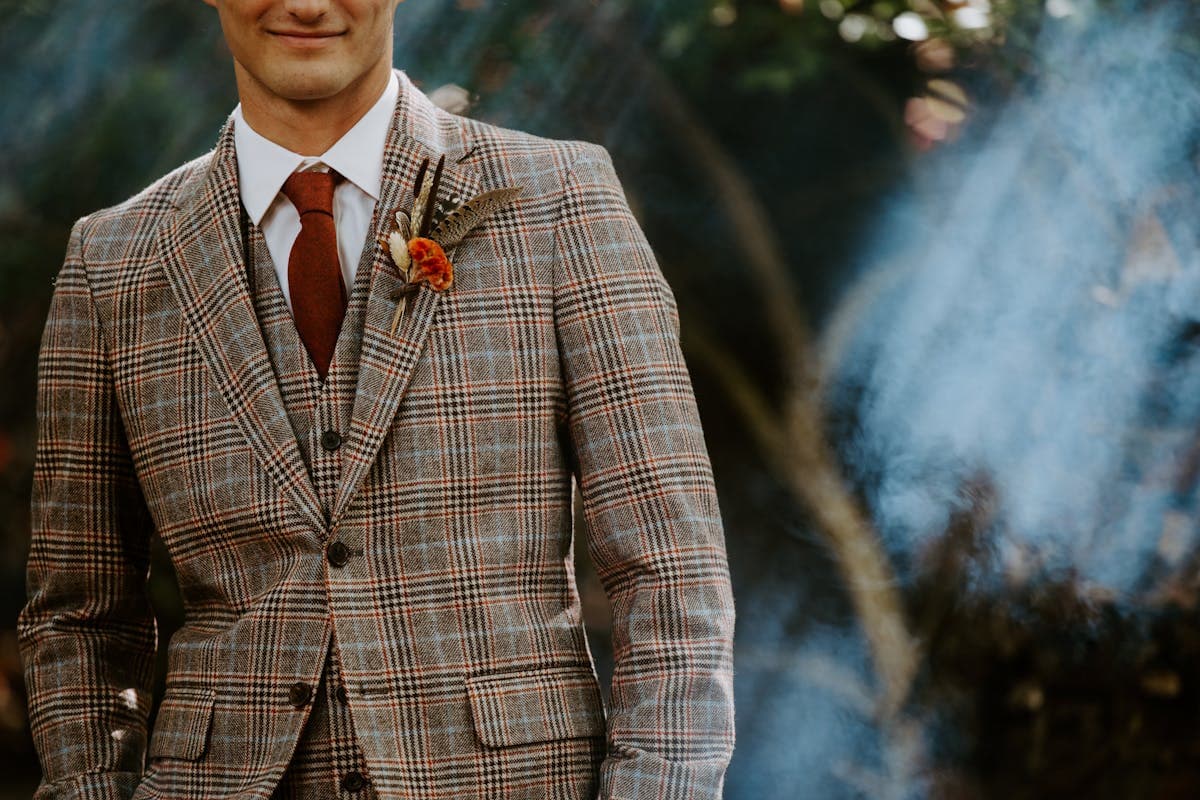 Man in a three-piece tweed suit with waistcoat in an autumn countryside setting