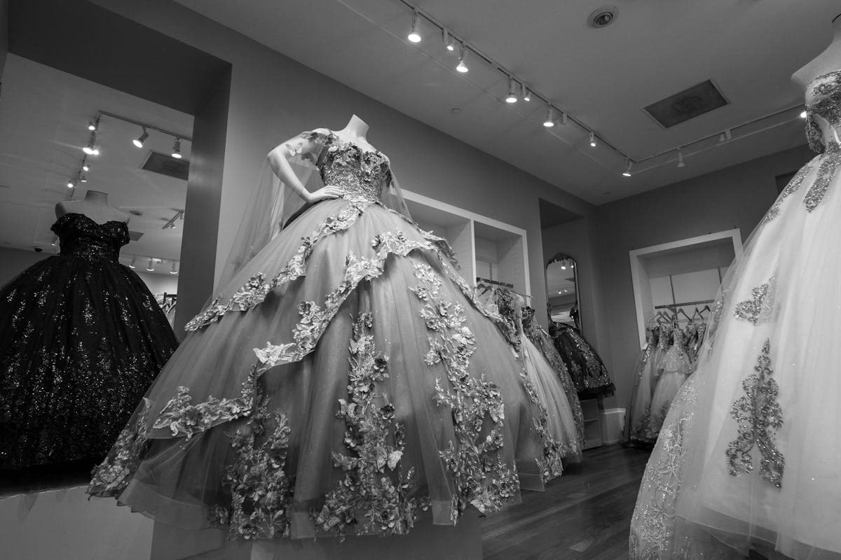Elegant formal evening gown displayed on a mannequin in a softly lit atelier