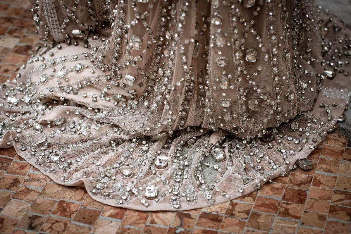 Close-up of detailed beadwork and flowing fabric on a formal evening gown
