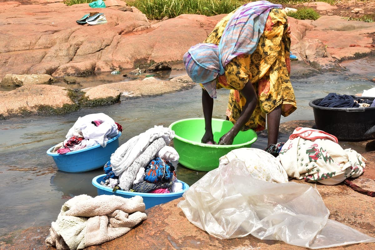 Silk garment being hand-washed gently in a basin of cold water with mild detergent, showing at-home silk care