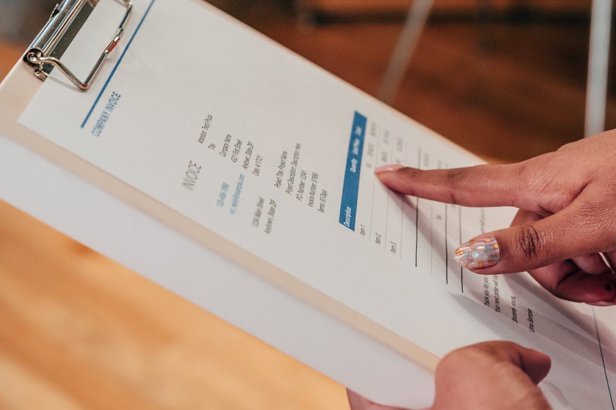 Person reviewing an itemized price quote with a pen, checking line items