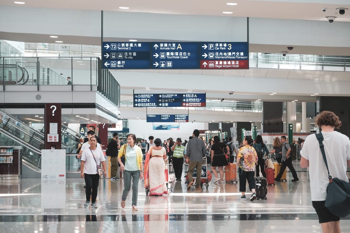 Modern airport arrivals hall in Vietnam with travelers collecting bags and heading toward the exit