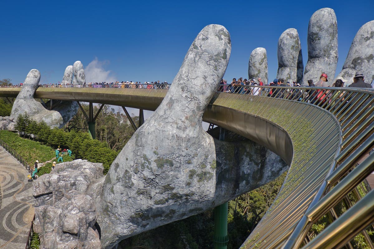 The Golden Bridge at Ba Na Hills held up by two giant stone hands above the mountains near Da Nang, Vietnam