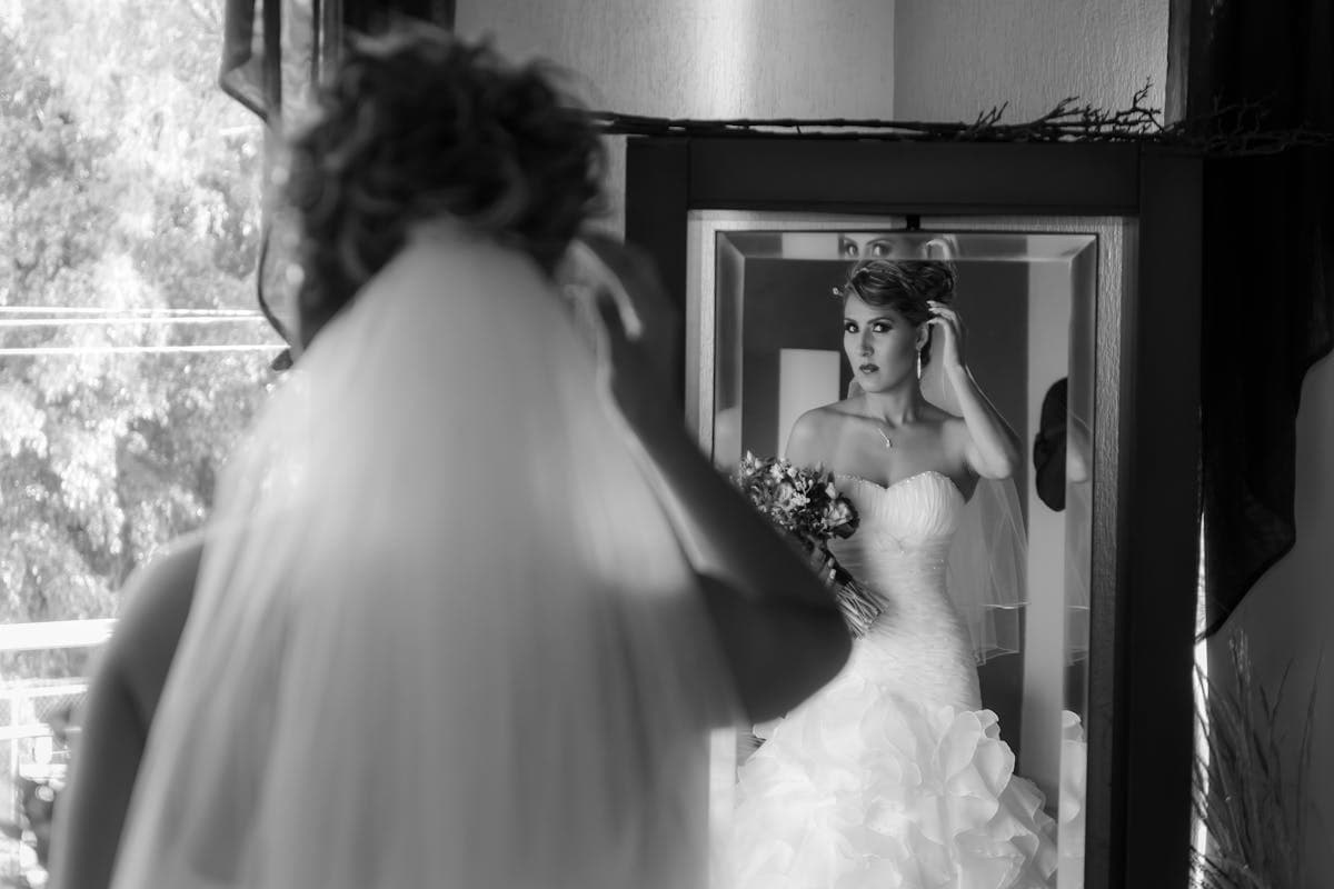 A bride in a fitted white gown getting ready on her wedding morning