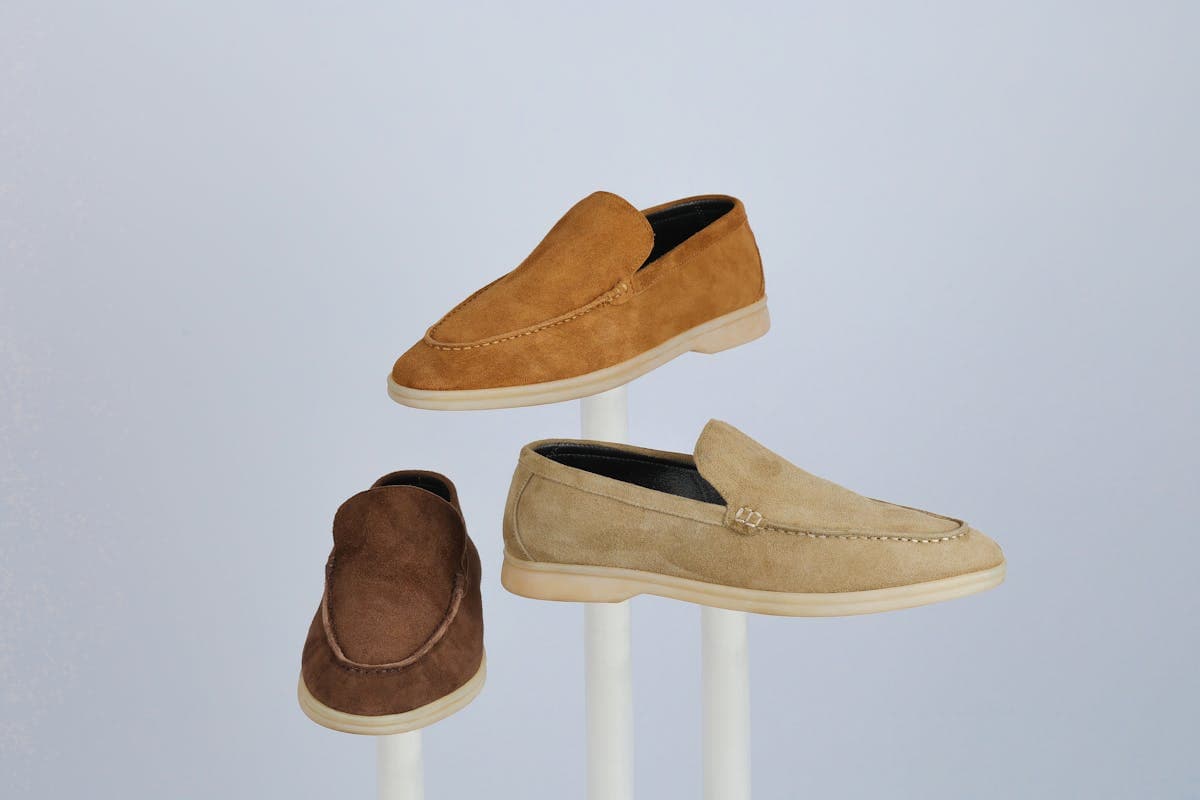 Tan suede loafers and brown leather boots arranged for a warm-weather wedding