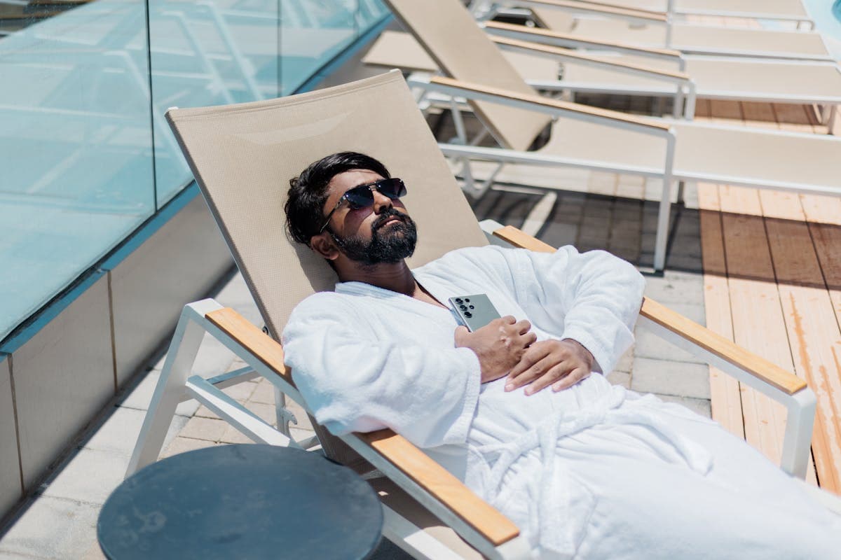 Groom in a light linen suit beside mid-century modern architecture and a pool deck in Palm Springs