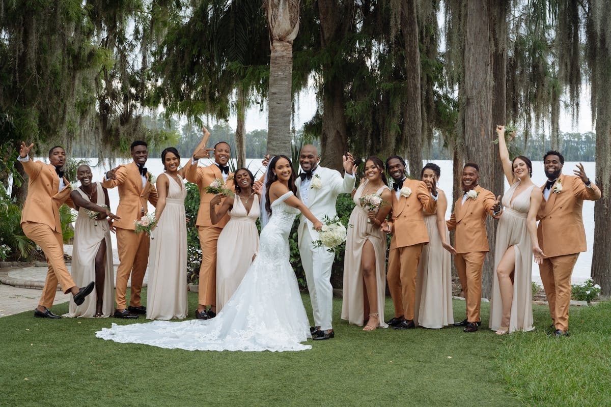Groomsmen in tan suits and boots at a rustic Texas Hill Country ranch wedding with string lights