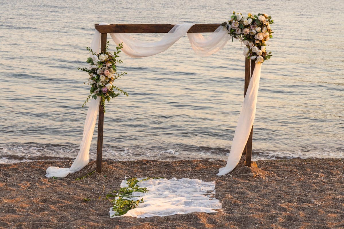 Beachfront wedding ceremony arch and white chairs on the sand at sunset along the central Vietnam coast near An Bang Beach