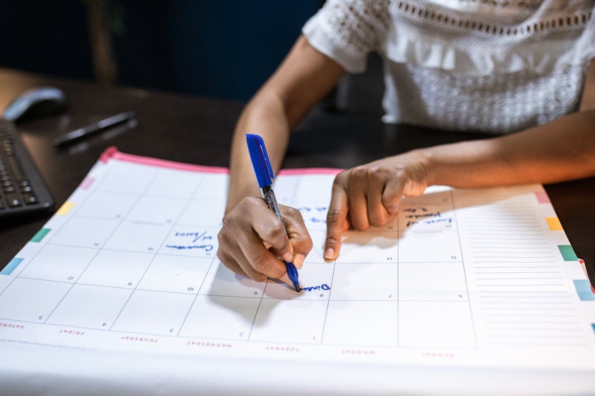 Person organizing wedding plans on a smartphone surrounded by swatches, notes, and a calendar