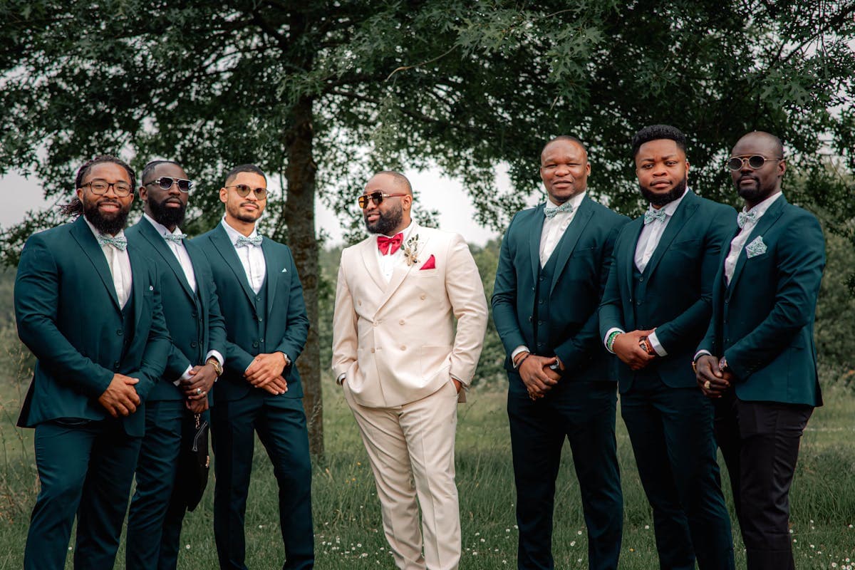 Group of groomsmen in well-fitted coordinated suits standing together at a wedding