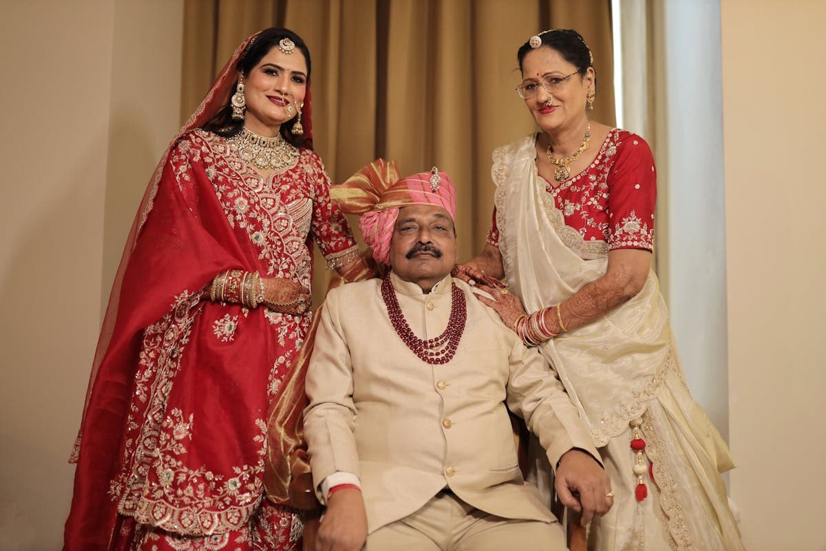 Bride, groom and both sets of parents lined up together at a wedding for a group photograph