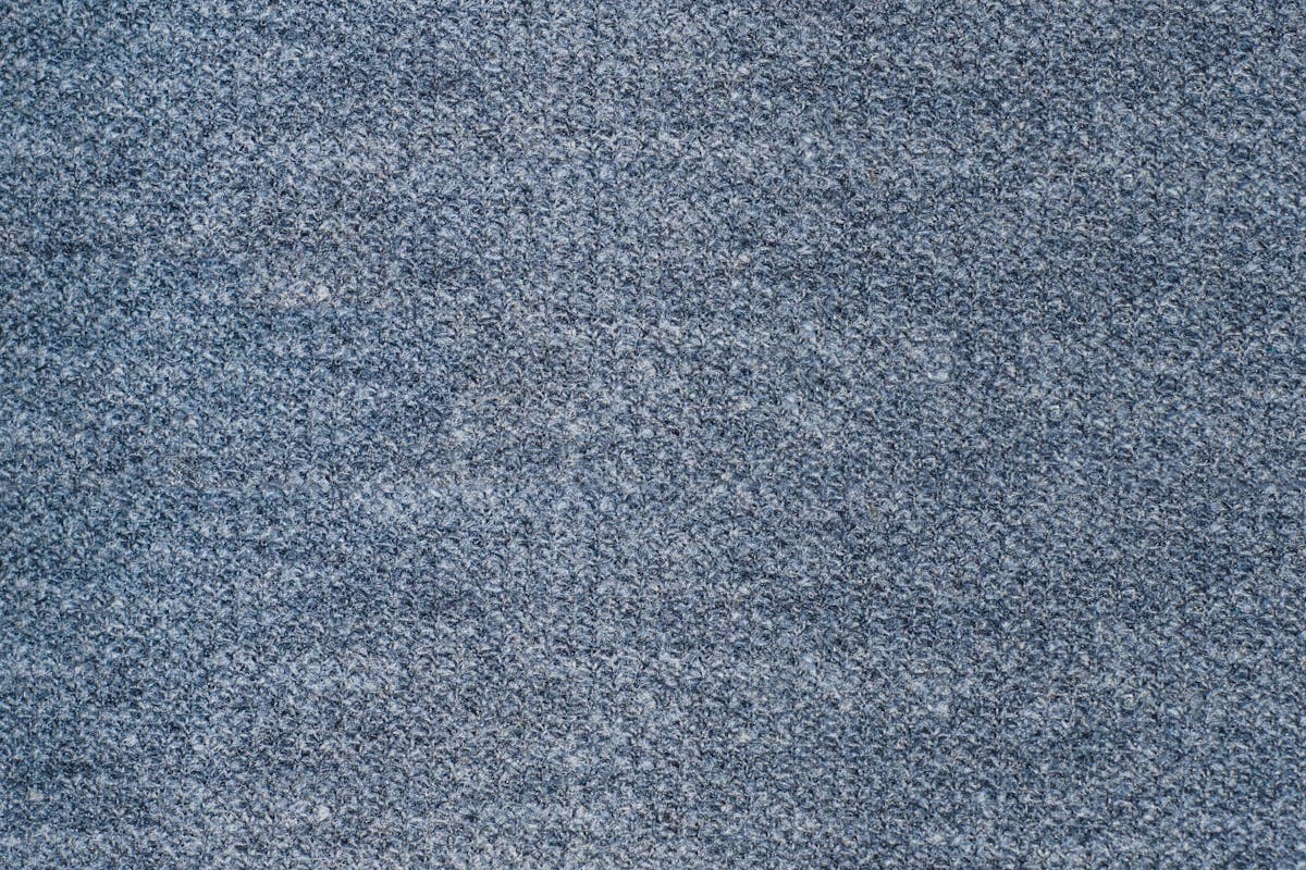 Close-up of folded wool suiting fabric swatches in navy and grey showing weave texture