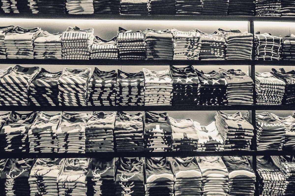 Stack of crisp folded custom dress shirts in cotton, the recommended first order for a Hoi An tailor first-timer