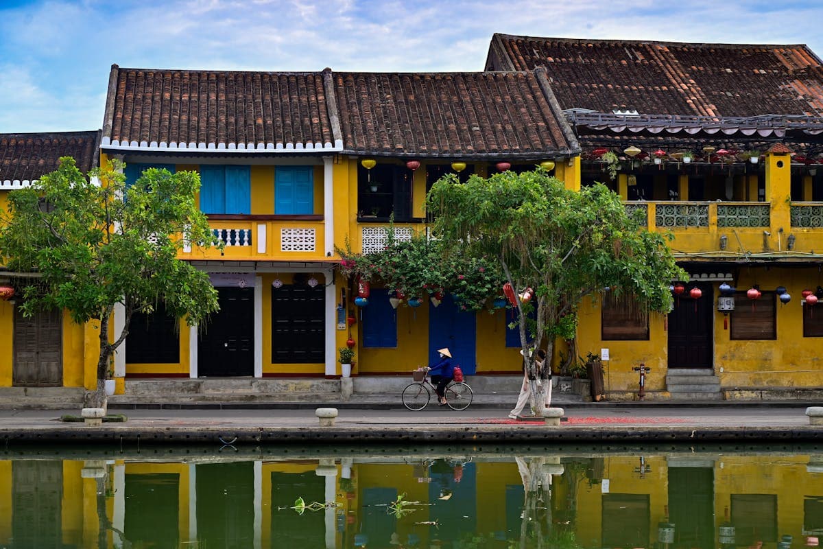 The Thu Bon River and yellow heritage buildings of Hoi An Old Town in the calm of morning