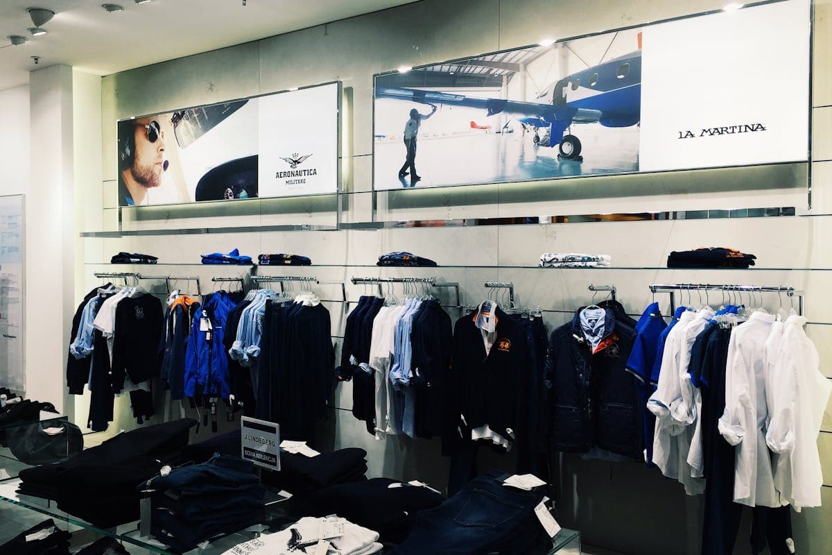 Folded and hung suit jackets displayed in a bright department store menswear section