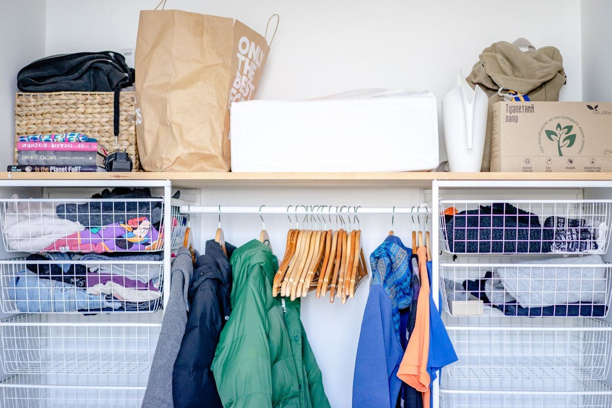 Row of identical rented suits hanging in protective garment bags on a retail rack