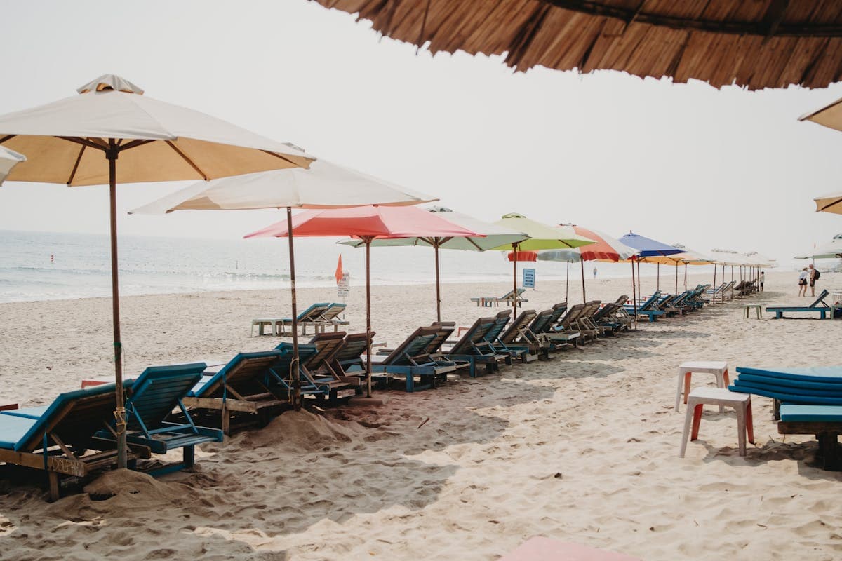 Sun loungers and a fresh coconut on the wide quiet sand of An Bang Beach with calm turquoise water behind