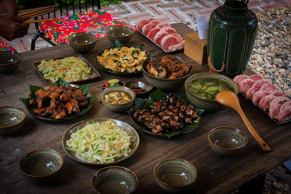 A spread of Vietnamese dishes shared family-style on a table, including spring rolls and noodle bowls