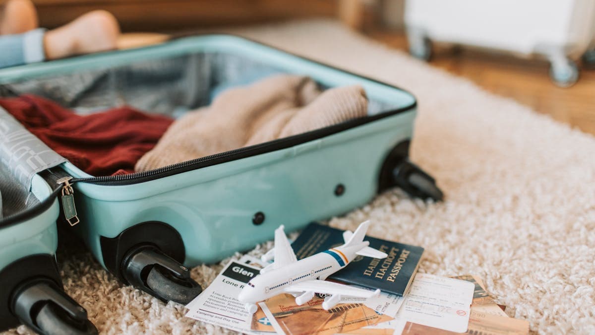 Overflowing suitcase with custom tailored clothes, fabric, and shopping bags from Hoi An Vietnam