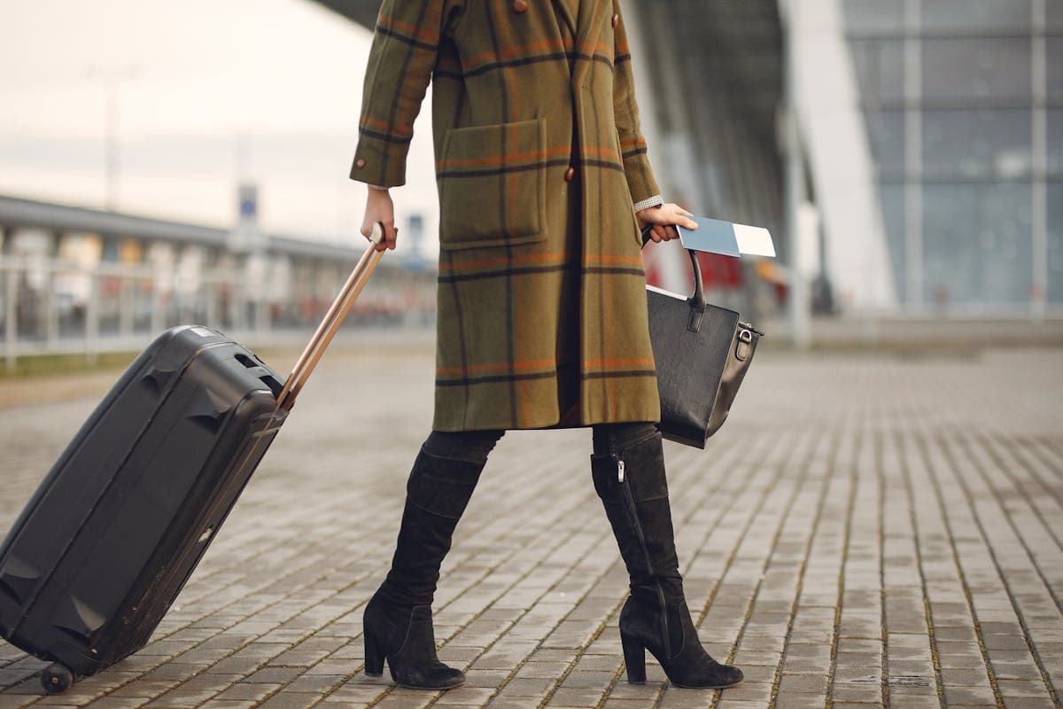 Traveler wearing a heavy coat and layered jacket while walking through an airport terminal