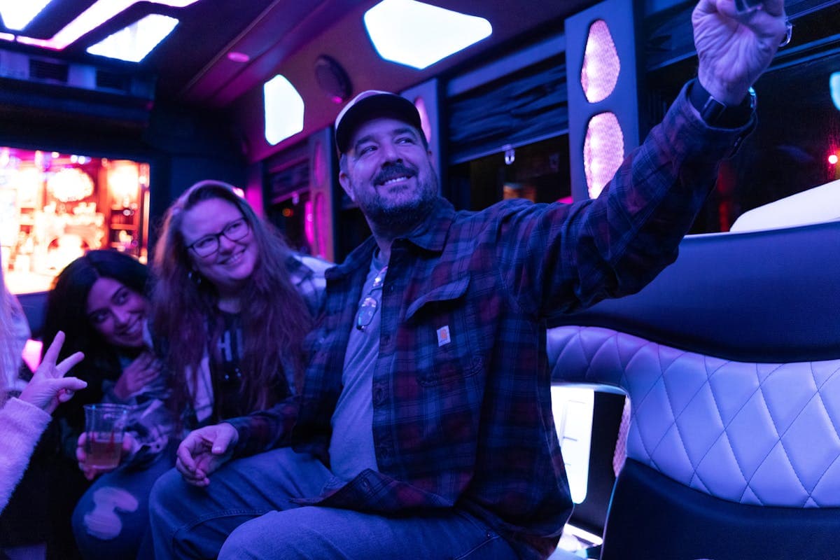 A group of friends laughing together inside a party bus at night
