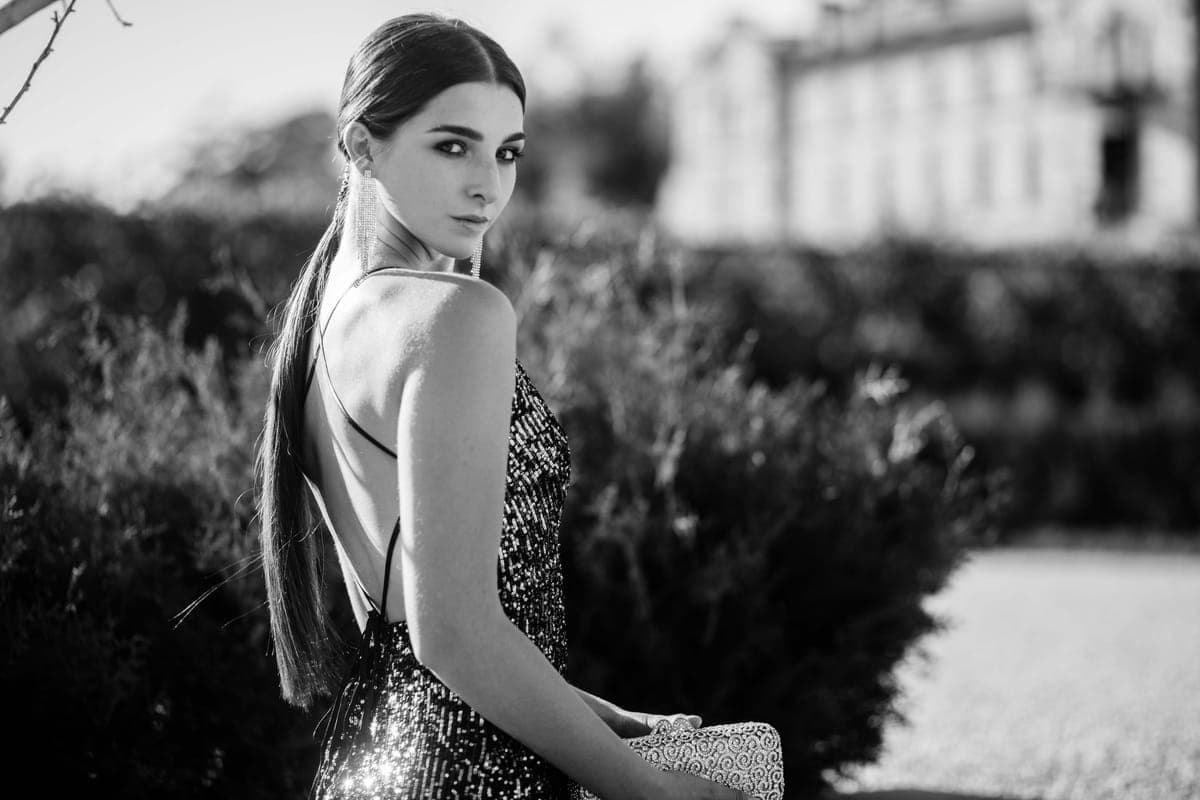 Back view of a woman in a gown with a deep open V-back and delicate strap detailing