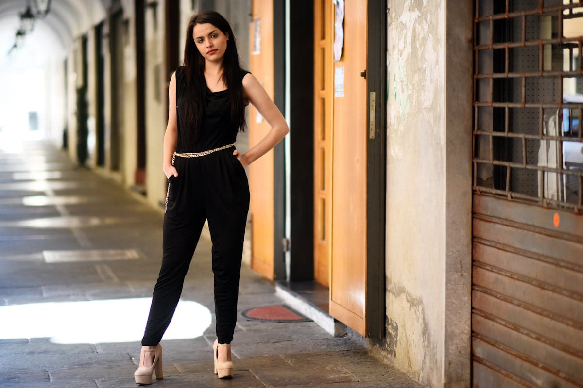 Woman in a tailored wide-leg satin jumpsuit posing confidently, the trousers flowing as she moves