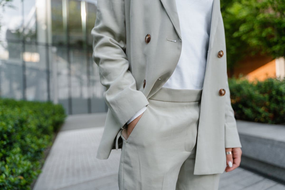 Close-up of leather penny loafers worn with tailored suit trousers and no socks visible