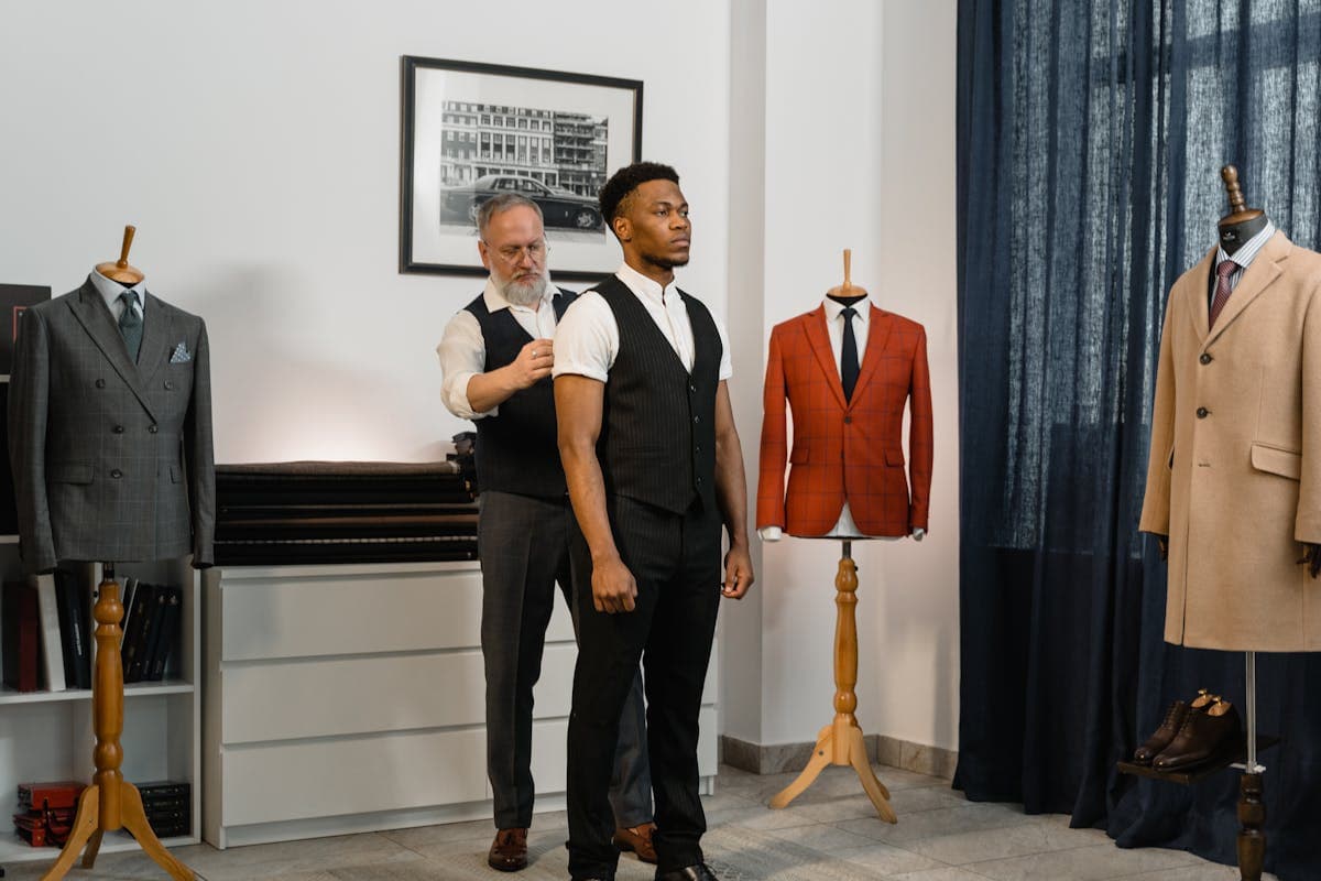 Two men in different style tailored suits standing in natural light