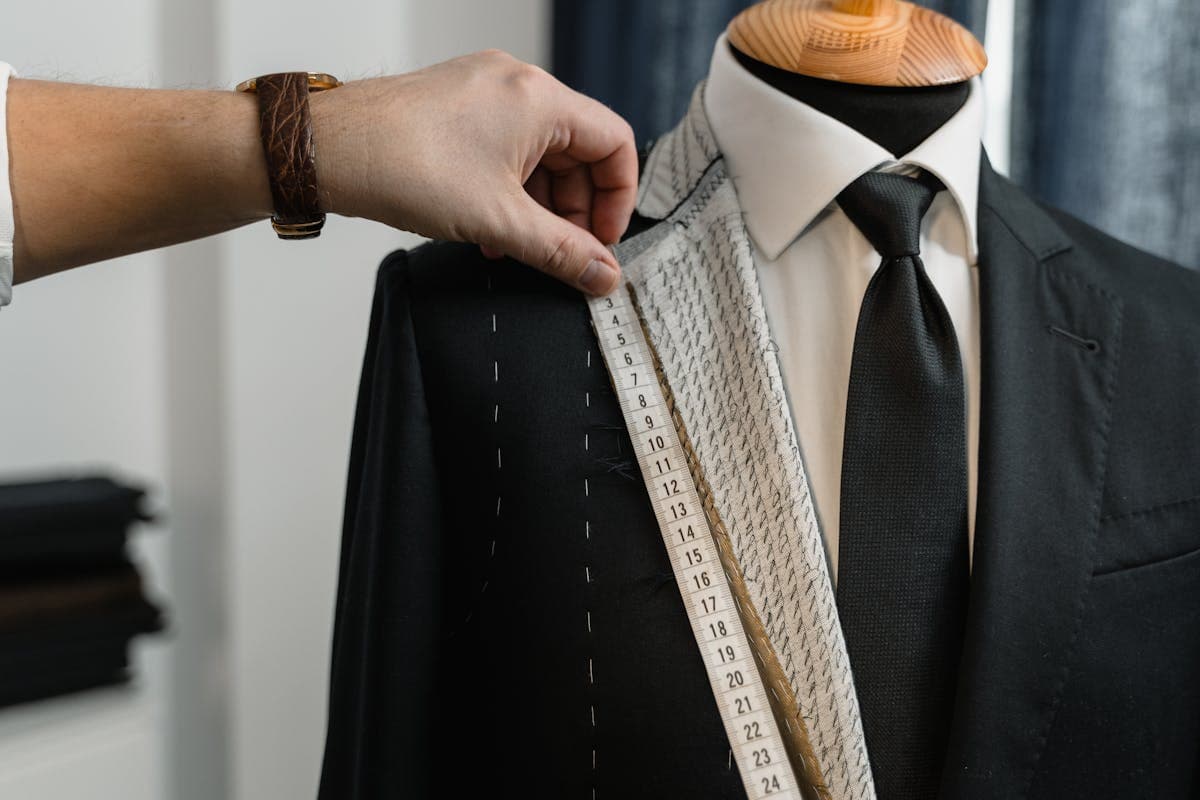 Close-up detail of a suit jacket lapel, buttonhole pick stitching and working cuff button