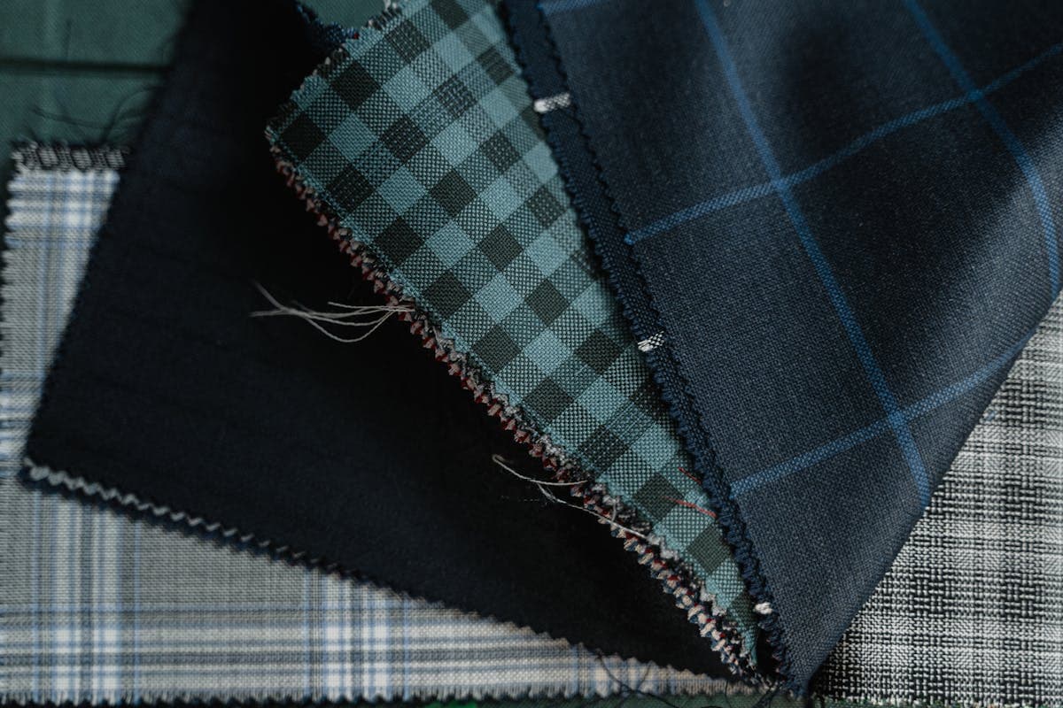 Close-up of folded wool suiting fabric swatches in grey and navy with visible weave