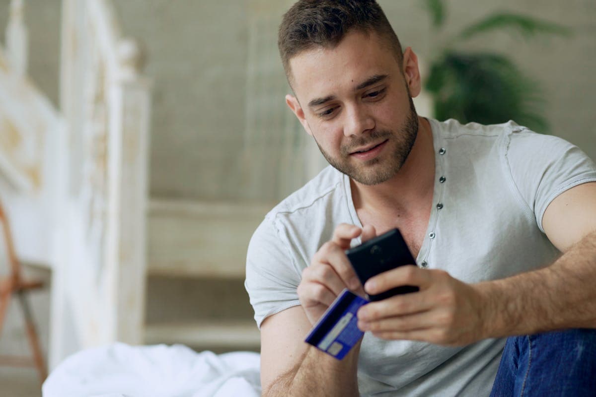 Person reviewing a payment confirmation on their phone at home, illustrating how remote customers verify and trust a Hoi An tailor from thousands of miles away