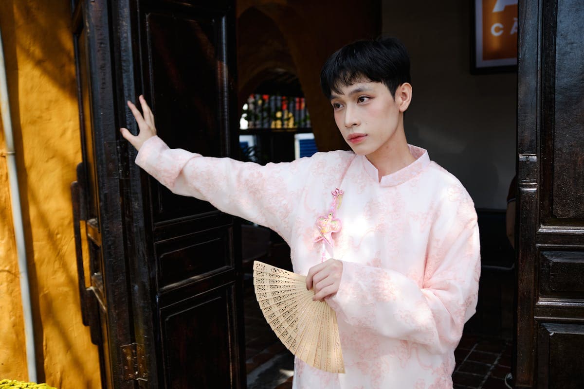 Vietnamese man wearing a structured brocade ao dai tunic over trousers, the formal men's version of the national dress