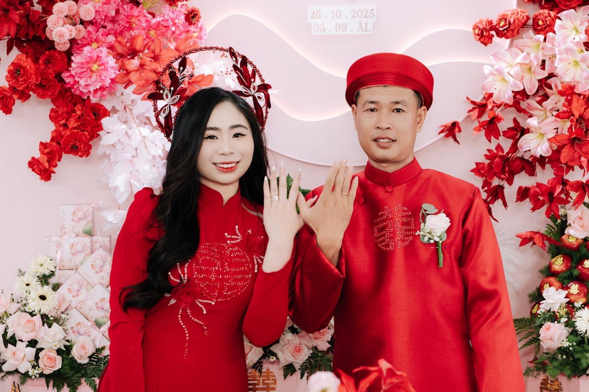 Vietnamese bride and groom in ornate matching red and gold embroidered wedding ao dai