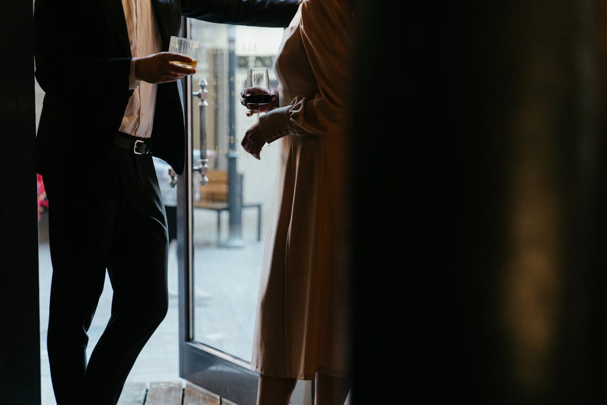 Two people both in tailored suits coordinating with contrasting neutral colors and a shared accent