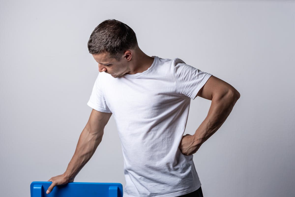 Person in a thin fitted t-shirt holding a flexible cloth tape measure