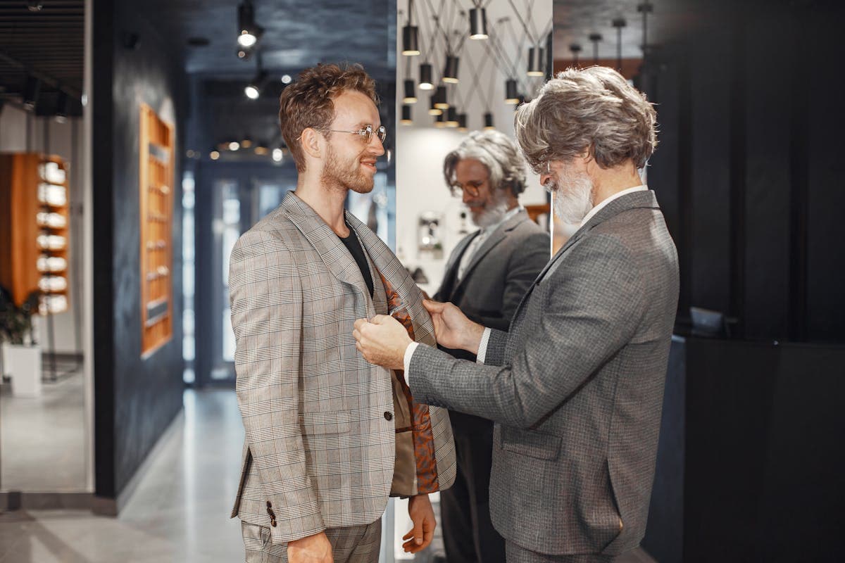 Suit jacket on a person being adjusted with fitting pins at the shoulder seam