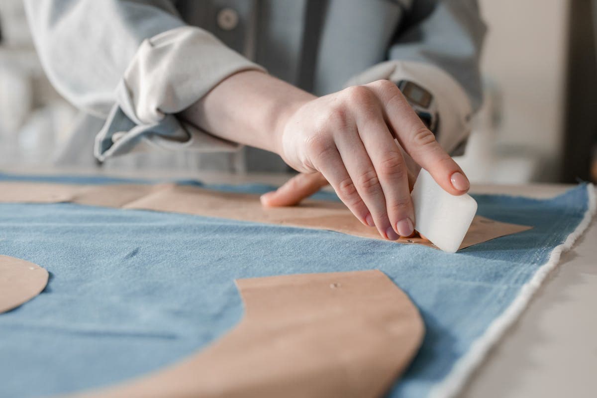 Tailor marking a suit pattern on cloth with tailor's chalk before cutting