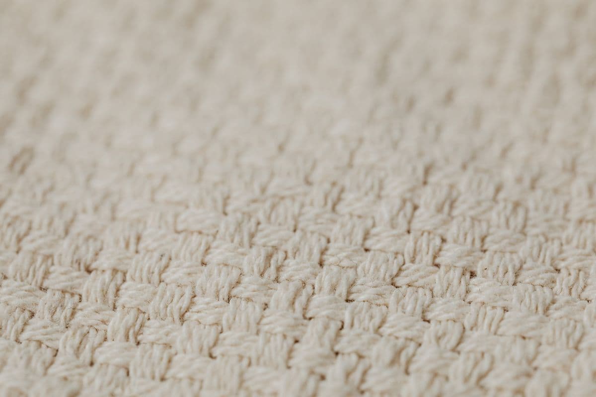 Close-up of linen and lightweight wool suiting fabrics in navy and grey, showing weave and texture differences