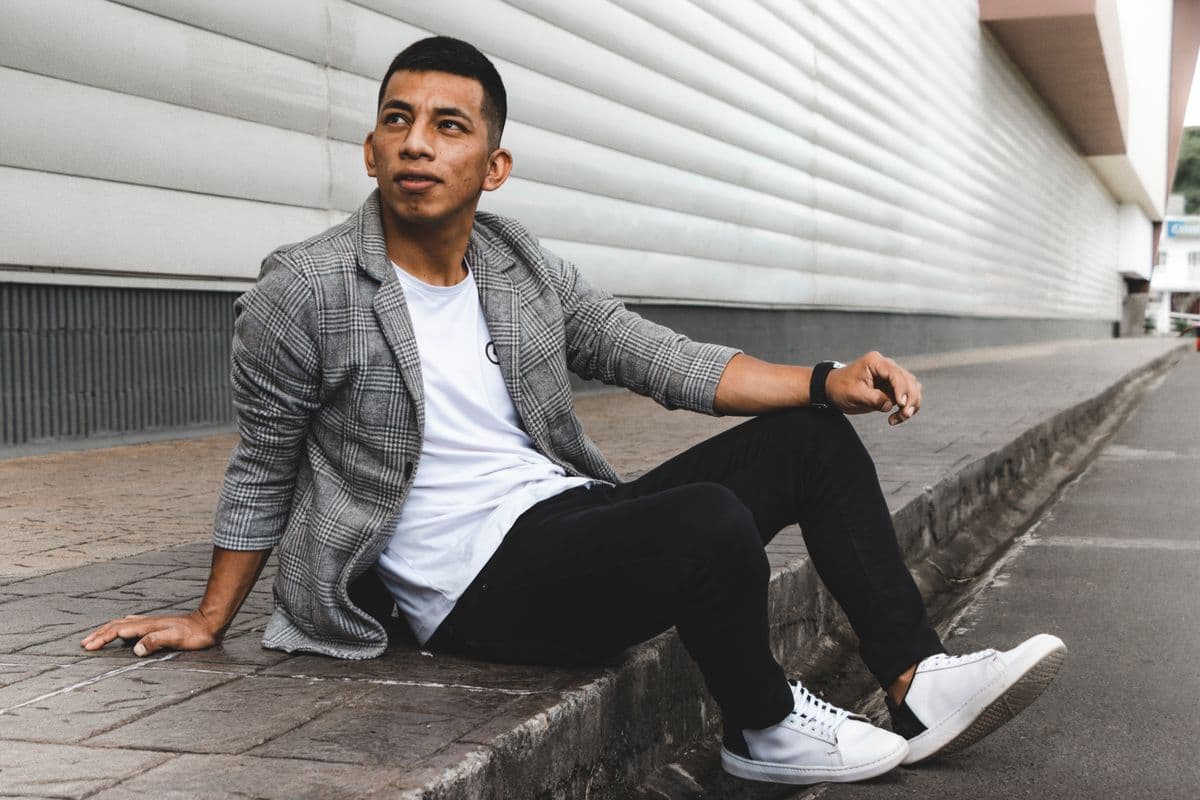 Man pairing a tailored blazer with a crewneck t-shirt and loafers in a relaxed casual setting