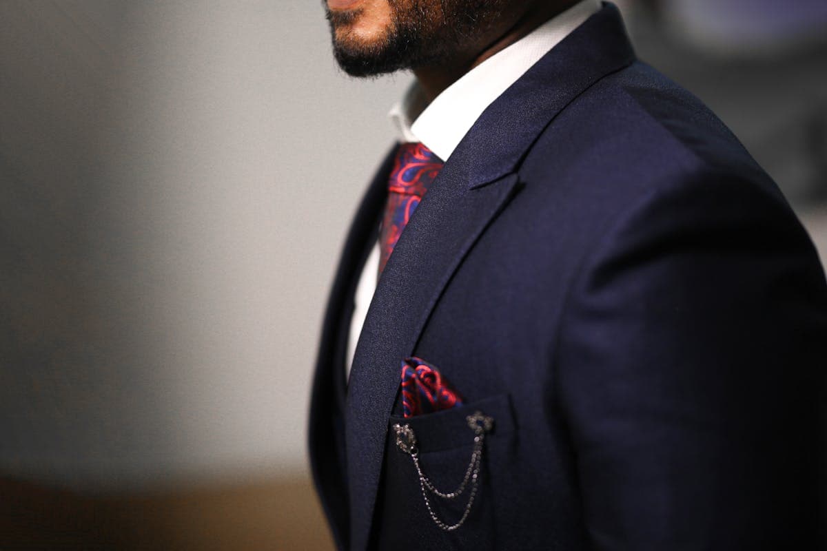 Close-up of a tailored single-breasted jacket with wide peak lapels on a well-fitted suit